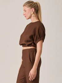 Esta blusa café para mujer destaca por su corte tipo crop con caída suave y cuello redondo. La Blusa Agostina Café es ideal para crear outfits contemporáneos y sofisticados para el día o la noche.