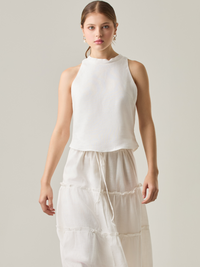 Esta blusa sin mangas refleja una elegancia natural con su cuello redondeado y acabado suave. El diseño se enfoca en la simplicidad, resaltando su frescura y ligereza. Perfecta para combinar con faldas o pantalones, ofrece una versatilidad ideal para días cálidos o eventos casuales.

Detalles:

Color: Blanco Perla