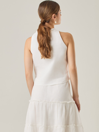 Esta blusa sin mangas refleja una elegancia natural con su cuello redondeado y acabado suave. El diseño se enfoca en la simplicidad, resaltando su frescura y ligereza. Perfecta para combinar con faldas o pantalones, ofrece una versatilidad ideal para días cálidos o eventos casuales.

Detalles:

Color: Blanco Perla