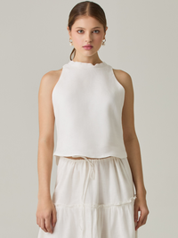 Esta blusa sin mangas refleja una elegancia natural con su cuello redondeado y acabado suave. El diseño se enfoca en la simplicidad, resaltando su frescura y ligereza. Perfecta para combinar con faldas o pantalones, ofrece una versatilidad ideal para días cálidos o eventos casuales.

Detalles:

Color: Blanco Perla

Material: 100% lino. 