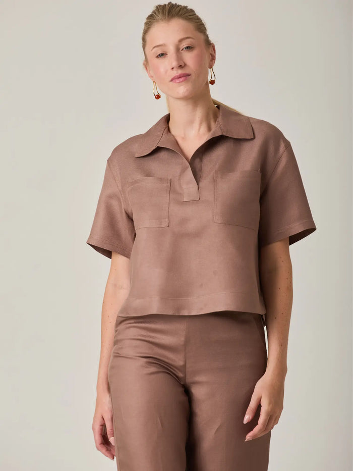 Blusa para mujer en color cafe con diseño minimalista y corte recto que aporta una silueta moderna y sofisticada. Ideal para looks casuales o elegantes, esta blusa cafe de manga corta es perfecta para combinar con pantalones de tiro alto o conjuntos monocromaticos.