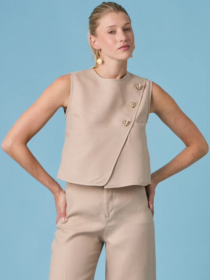 Blusa Aston Nude elegante para mujer, confeccionada en tono nude con detalle de botones laterales que aporta sofisticación y estilo contemporáneo.