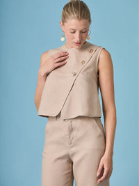 Blusa Aston Nude estilo minimal chic con botones metálicos decorativos, ideal para outfits sofisticados y combinaciones atemporales.