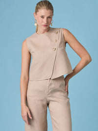Blusa Aston Nude de diseño minimalista con corte sin mangas y botones decorativos, ideal para looks elegantes y modernos en climas cálidos.
