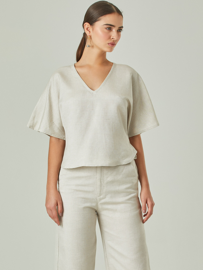 Blusa elegante con escote en V y mangas holgadas 3/4, su diseño es perfecto para utilizar con pantalones o faldas a tono.

 Detalles:

Color: Natural

Material: 52% Lino 48% Rayón 