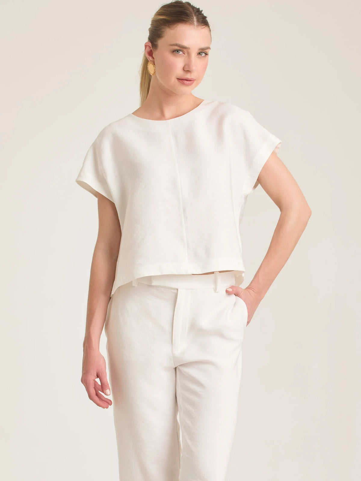 Blusa en color blanco puro con un diseño moderno y minimalista. Cuenta con escote redondo de acabado pulcro y mangas con caída de hombro que le otorgan una silueta fluida. La pieza presenta sutiles costuras verticales que aportan estructura. Su corte recto lo hace ideal tanto para looks casuales de verano como para outfits elegantes de estilo resort.

Detalles:

Color: Blanco

Material: 100% Lino