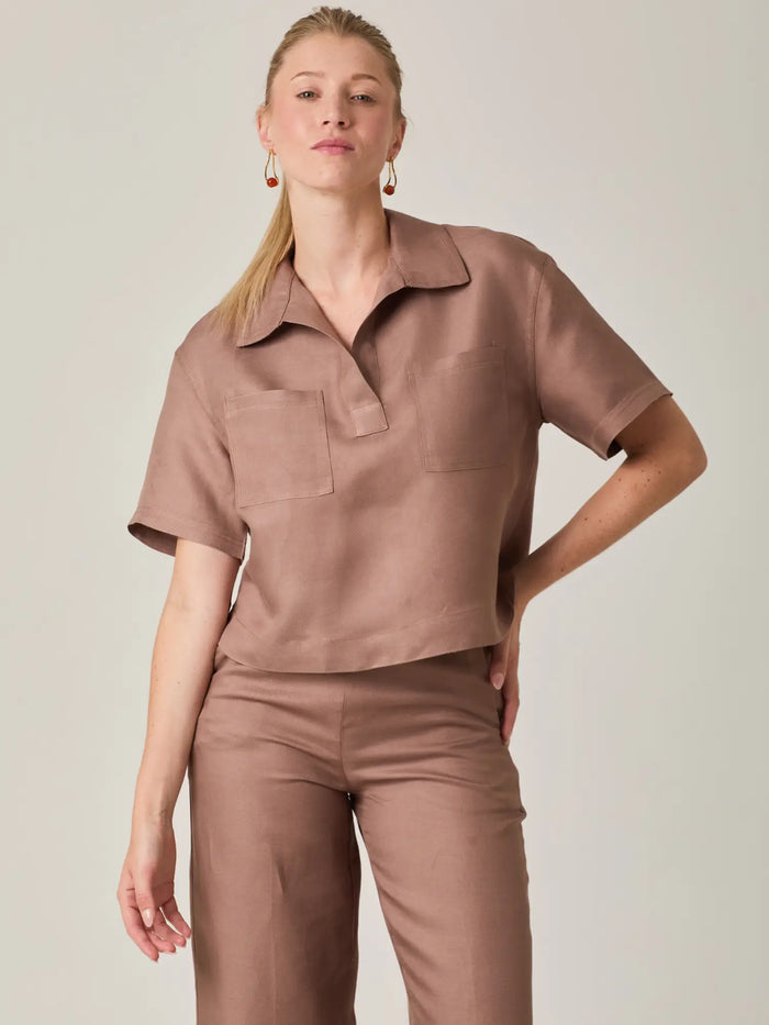 Blusa cafe para mujer con un diseño atemporal que equilibra comodidad y elegancia. Su cuello tipo polo y estructura ligera la convierten en una prenda versatil, ideal para outfits de oficina, reuniones o uso diario con un toque refinado.