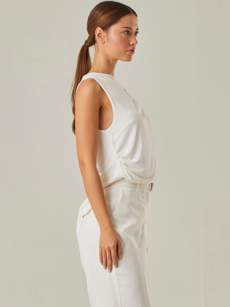 Esta blusa resalta por sus delicados pliegues en el frente. Es ideal para quienes buscan un estilo moderno y sutil, ofreciendo versatilidad para diversas combinaciones y ocasiones.