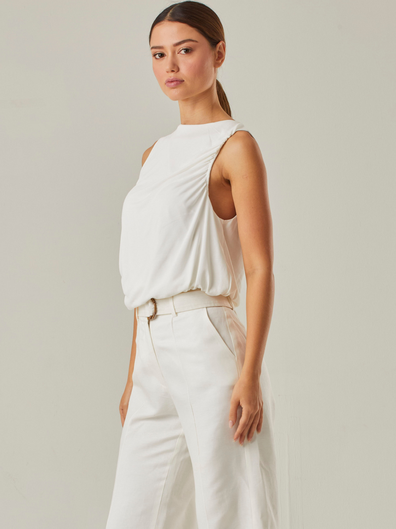 Esta blusa resalta por sus delicados pliegues en el frente. Es ideal para quienes buscan un estilo moderno y sutil, ofreciendo versatilidad para diversas combinaciones y ocasiones.