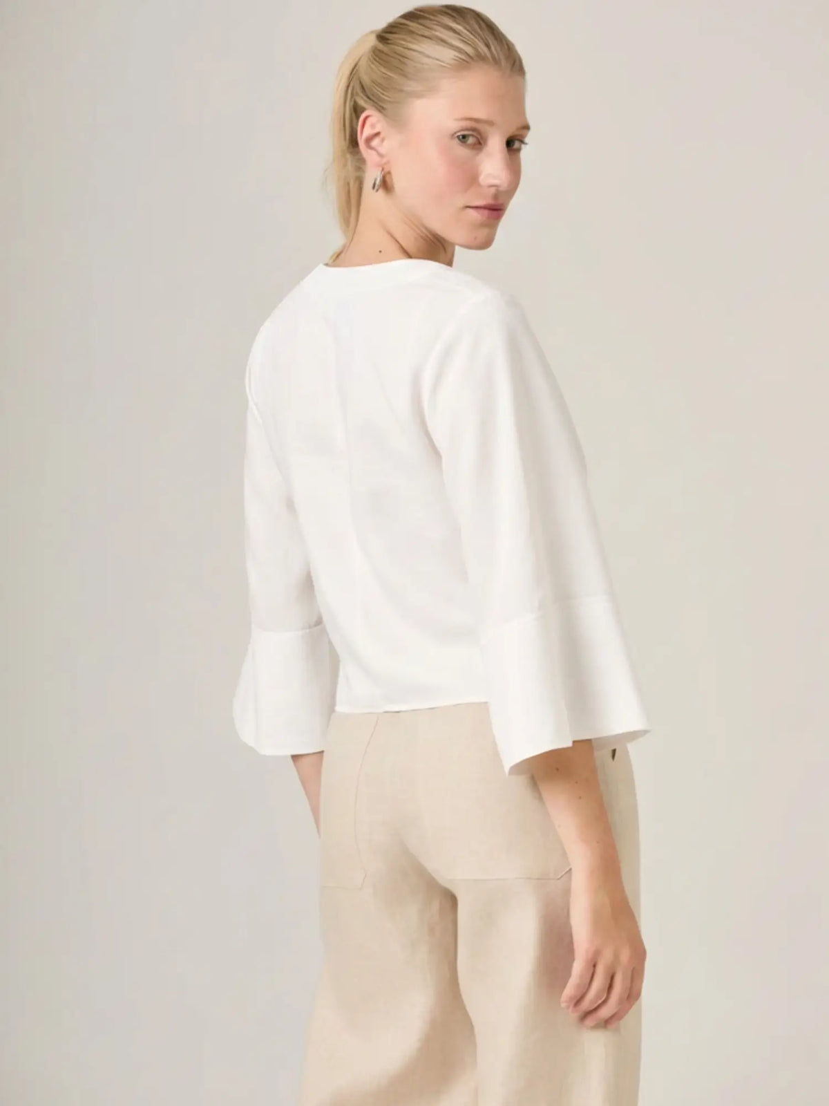 Blusa blanca femenina de diseño fluido y mangas amplias, perfecta para un look relajado pero refinado. La blusa micaela blanco es una prenda basica imprescindible para un guardarropa moderno.