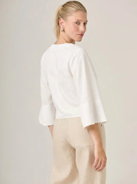 Blusa blanca femenina de diseño fluido y mangas amplias, perfecta para un look relajado pero refinado. La blusa micaela blanco es una prenda basica imprescindible para un guardarropa moderno.