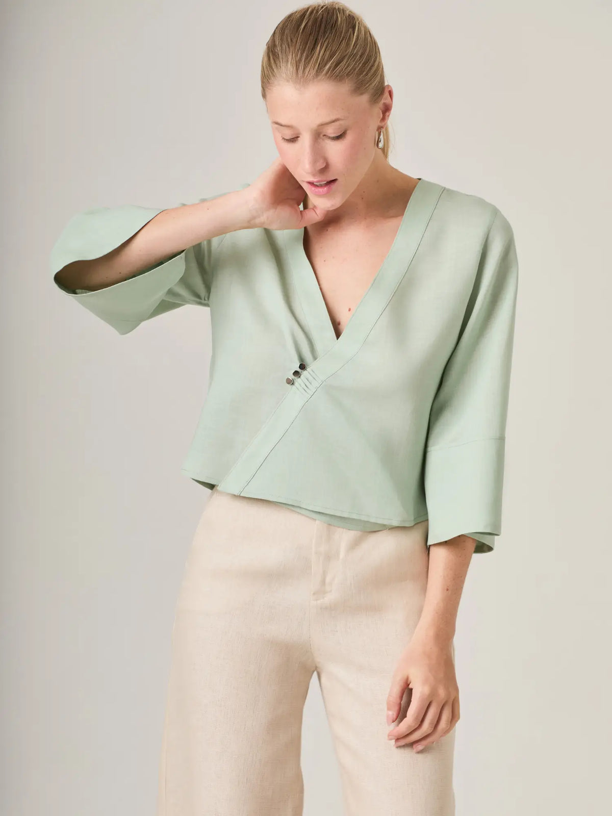 Blusa cruzada femenina con boton decorativo y escote profundo que aporta un toque sofisticado sin perder comodidad. Ideal para outfits de dia o eventos casuales, esta blusa verde menta es fresca y actual.
