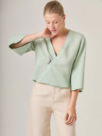 Blusa cruzada femenina con boton decorativo y escote profundo que aporta un toque sofisticado sin perder comodidad. Ideal para outfits de dia o eventos casuales, esta blusa verde menta es fresca y actual.