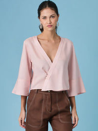 Blusa rosa para mujer con diseño cruzado y escote en V que estiliza la silueta. La blusa micaela rosa destaca por su caida suave y mangas amplias, ideal para looks femeninos, elegantes y modernos.