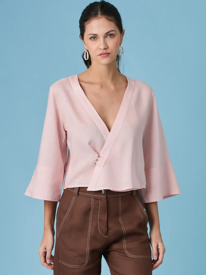 Blusa rosa para mujer con diseño cruzado y escote en V que estiliza la silueta. La blusa micaela rosa destaca por su caida suave y mangas amplias, ideal para looks femeninos, elegantes y modernos.