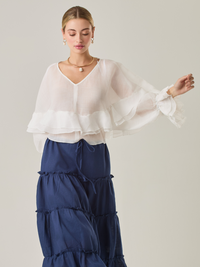 Blusa fluida con un diseño envolvente y detalles en capas que aportan volumen y movimiento. Su escote en V con botones añade un toque delicado, mientras que las mangas amplias con terminación elástica complementan su estilo sofisticado y femenino.

Color: Blanco perla

Material: 57% Rayón 43% Poliester.