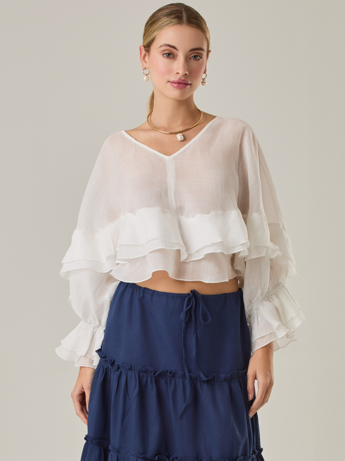 Blusa fluida con un diseño envolvente y detalles en capas que aportan volumen y movimiento. Su escote en V con botones añade un toque delicado, mientras que las mangas amplias con terminación elástica complementan su estilo sofisticado y femenino.

Color: Blanco perla

Material: 57% Rayón 43% Poliester.
