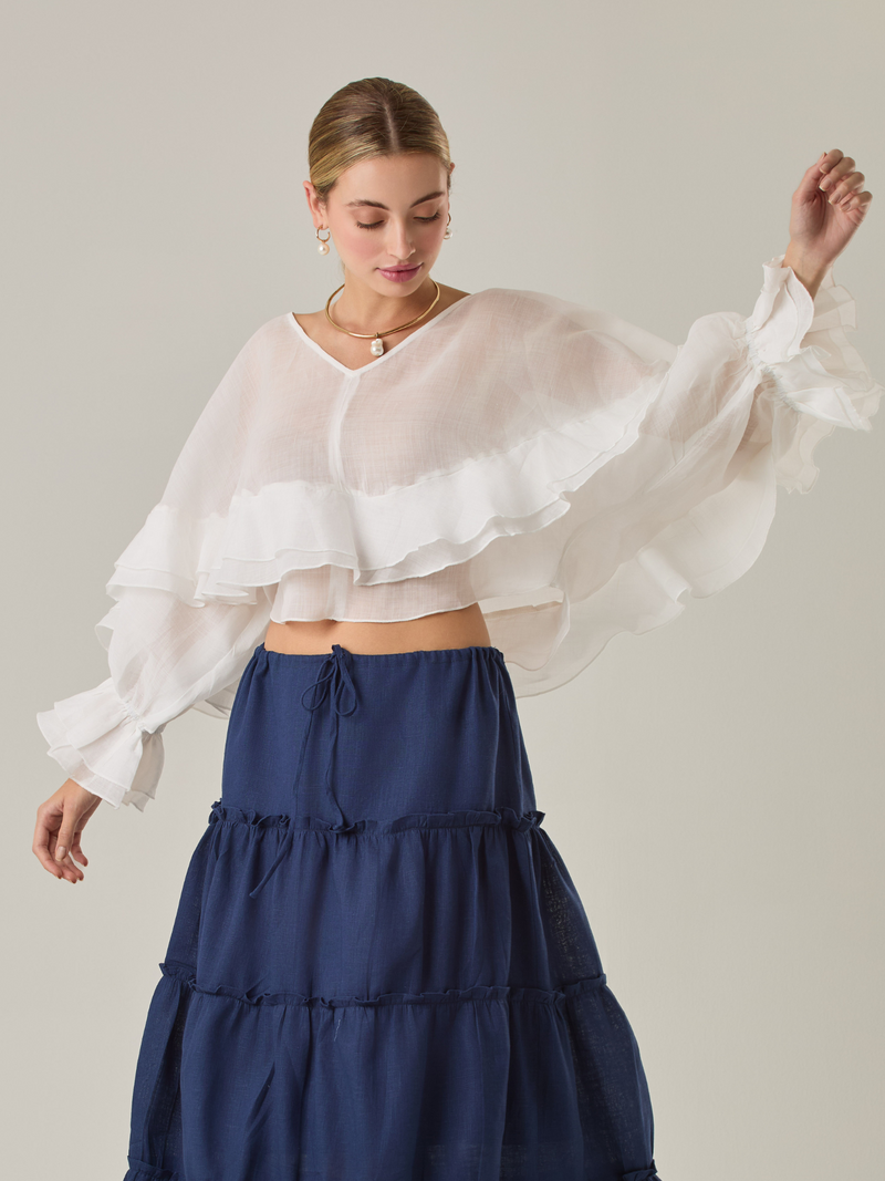 Blusa fluida con un diseño envolvente y detalles en capas que aportan volumen y movimiento. Su escote en V con botones añade un toque delicado, mientras que las mangas amplias con terminación elástica complementan su estilo sofisticado y femenino.

Color: Blanco perla

Material: 57% Rayón 43% Poliester.