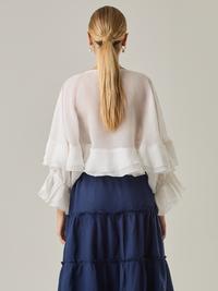 Blusa fluida con un diseño envolvente y detalles en capas que aportan volumen y movimiento. Su escote en V con botones añade un toque delicado, mientras que las mangas amplias con terminación elástica complementan su estilo sofisticado y femenino.

Color: Blanco perla

Material: 57% Rayón 43% Poliester.