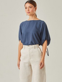 Blusa con un estilo relajado que combina comodidad y elegancia. Las mangas voluminosas, ajustables con delicados lazos, le otorgan un toque versátil, mientras que su corte fluido favorece una caída natural. Perfecta para crear looks modernos y atemporales.