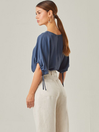 Blusa con un estilo relajado que combina comodidad y elegancia. Las mangas voluminosas, ajustables con delicados lazos, le otorgan un toque versátil, mientras que su corte fluido favorece una caída natural. Perfecta para crear looks modernos y atemporales.