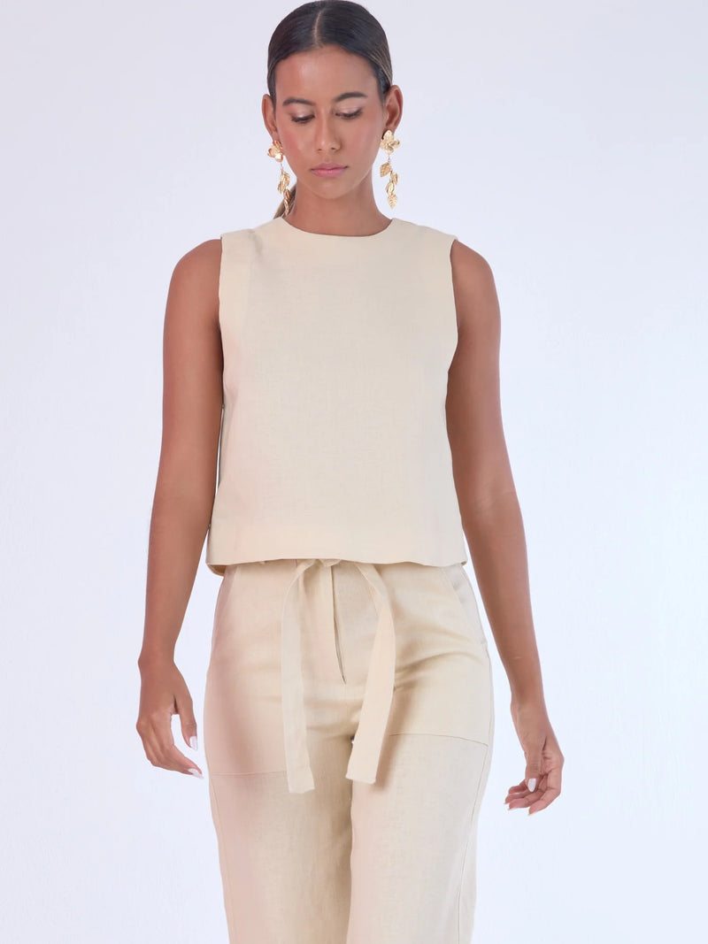 Blusa sin mangas de corte recto y silueta relajada. Tiene cuello redondo cerrado y un diseño limpio sin detalles visibles, lo que le da un estilo minimalista y moderno. El largo llega justo a la cintura, ideal para llevar por fuera o combinada con prendas de talle alto para un look fresco y sofisticado

Detalles:

Color: Sand

Material: 100% lino.&nbsp;