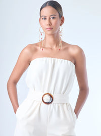 Jumpsuit sin tirantes de corte largo y silueta fluida. El diseño superior tiene un efecto fruncido en el escote elástico, que se ajusta suavemente al cuerpo. En la cintura destaca un cinturón ancho con hebilla redonda que define la figura. El pantalón cae recto hasta el tobillo con un estilo relajado y elegante. Ideal para un look moderno con aire minimalista.