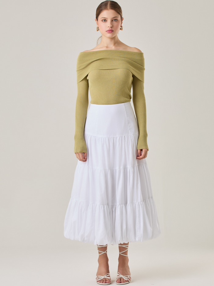 Esta es una falda blanca de largo midi con un diseño en capas que crea un efecto abombado en la parte inferior. Está hecha en una tela liviana y con caída. Tiene un estilo romántico y femenino, ideal para combinar con blusas ajustadas o crop tops. En la imagen se lleva con un suéter off-shoulder que le da un look sofisticado.

Detalles:

Color: Blanco

Material: 54% Rayón 31% Algodón 15% Lino