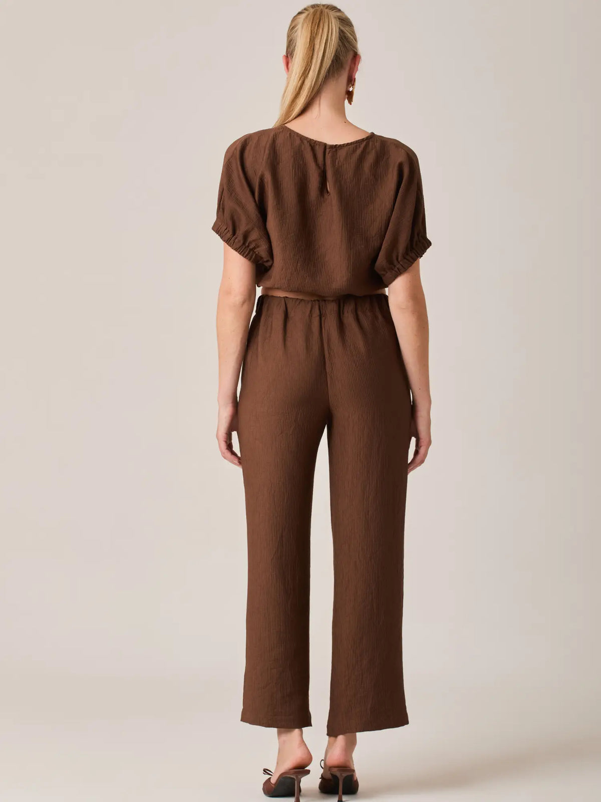 Con un diseño limpio y elegante, el Pantalón Largo Agostina Café es perfecto para looks relajados con un toque sofisticado. Su corte largo estiliza la silueta femenina.