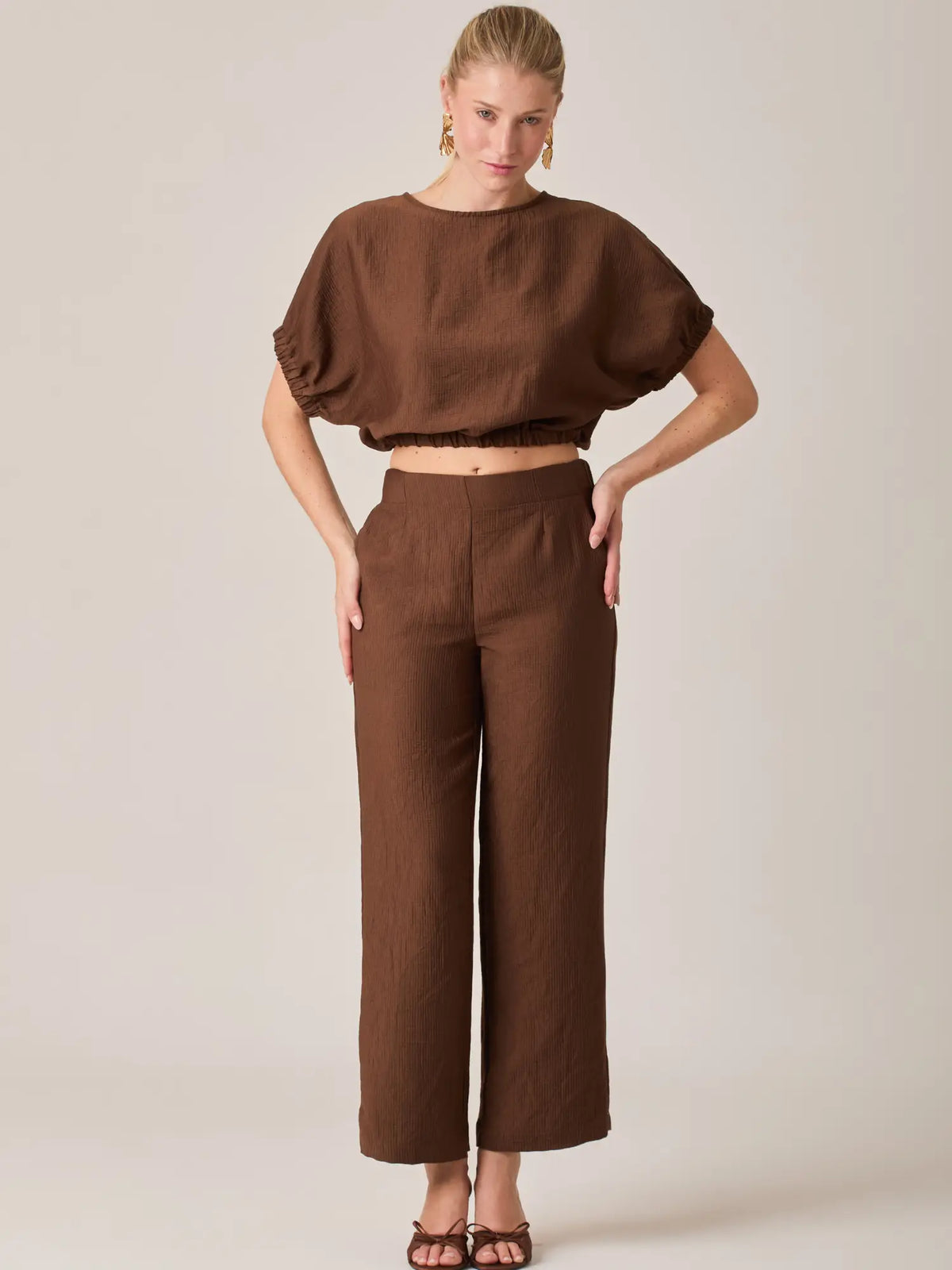 Este pantalón café para mujer destaca por su silueta recta y diseño cómodo. El Pantalón Largo Agostina Café es ideal para combinar con blusas cortas o tops ajustados y crear outfits modernos.