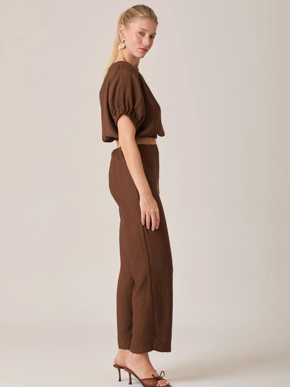 El Pantalón Largo Agostina Café es una prenda clave del guardarropa femenino gracias a su diseño atemporal y su color neutro, perfecto para outfits monocromáticos o combinaciones sofisticadas.