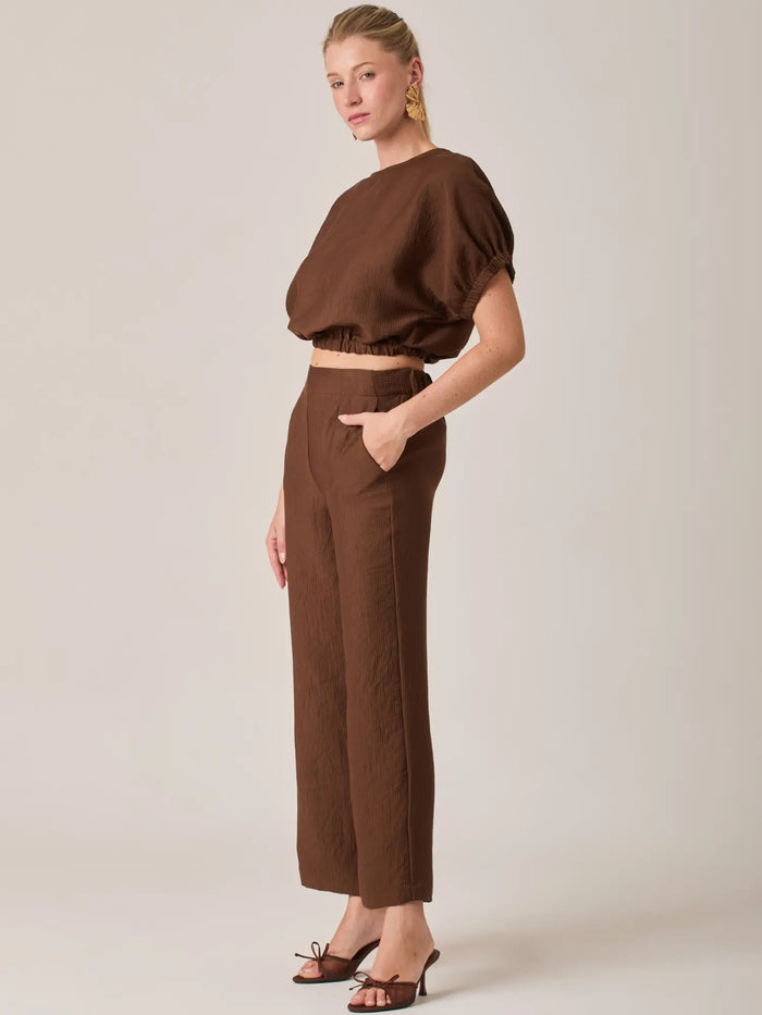 Diseñado para brindar comodidad sin perder estilo, el Pantalón Largo Agostina Café ofrece un ajuste favorecedor y una estética minimalista ideal para looks casual chic.