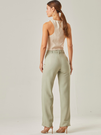 Este pantalón de tiro alto presenta un corte recto clásico que estiliza la silueta y alarga visualmente las piernas. Está confeccionado en una tela de textura suave y caída ligera, lo que lo hace ideal tanto para looks formales como casuales. Su diseño incluye bolsillos laterales discretos y trabillas para cinturón, aportando funcionalidad sin perder la sofisticación, es  una prenda versátil y moderna, perfecta para combinar con tops neutros o en contraste.

Detalles:

Color: Verde