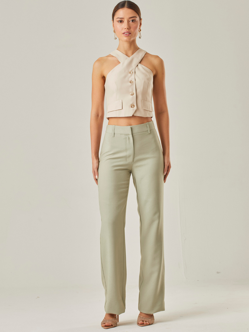 Este pantalón de tiro alto presenta un corte recto clásico que estiliza la silueta y alarga visualmente las piernas. Está confeccionado en una tela de textura suave y caída ligera, lo que lo hace ideal tanto para looks formales como casuales. Su diseño incluye bolsillos laterales discretos y trabillas para cinturón, aportando funcionalidad sin perder la sofisticación, es  una prenda versátil y moderna, perfecta para combinar con tops neutros o en contraste.

Detalles:

Color: Verde