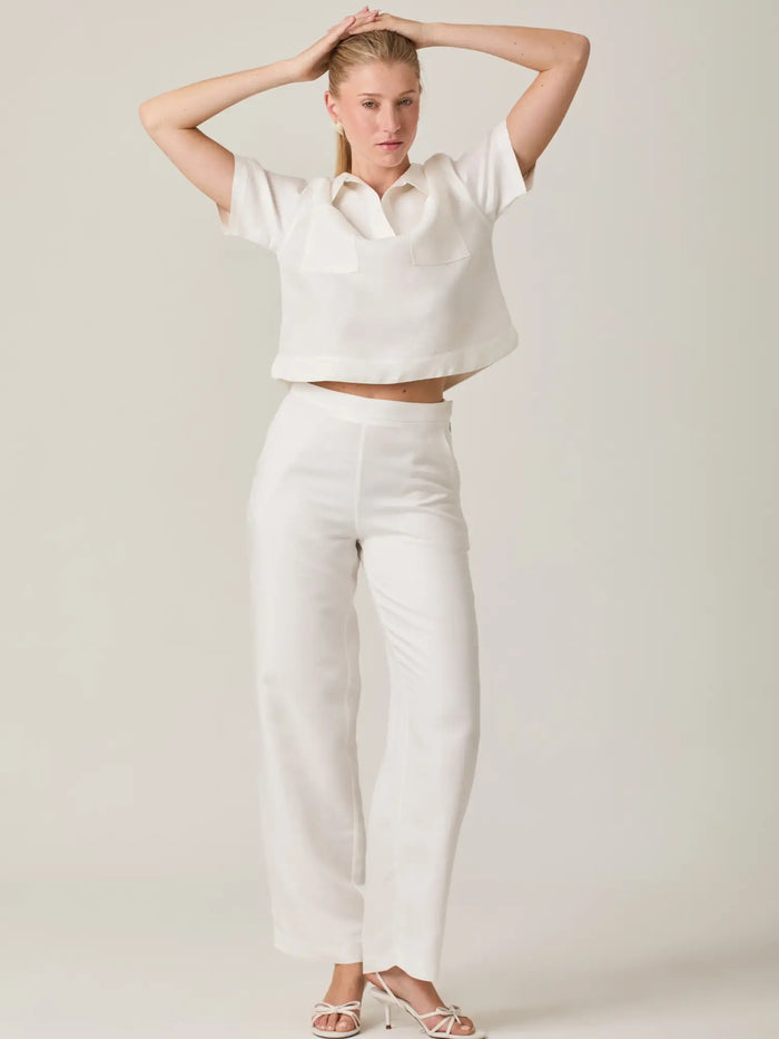 Pantalón largo blanco para mujer con corte recto y acabado minimalista. Diseñado para brindar comodidad y sofisticación, es perfecto para outfits frescos y atemporales, ideal tanto para el día a día como para ocasiones especiales.