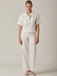 Pantalón largo para mujer en color blanco con silueta recta y tiro medio que estiliza la figura. Su diseño limpio y versátil lo convierte en una prenda ideal para looks elegantes, casuales o de oficina, fácil de combinar con blusas y tops de la colección.