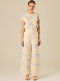 Pantalón de tiro alto con silueta amplia y pierna recta. Confeccionado en tejido liviano y suave, presenta estampado de palmeras a lo largo de ambas piernas que aporta un aire tropical y relajado. Su diseño estructurado combina comodidad y estilo, ideal para días de verano con un toque distintivo.

Detalles:

Color: Sand