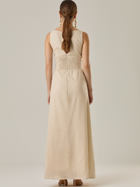 Vestido largo sin mangas con escote sutilmente curvado. El talle entallado contrasta con la amplitud de la falda, creando una silueta fluida y elegante. Una propuesta fresca, pensada para climas cálidos o eventos al aire libre, con un aire relajado que no pierde sofisticación.