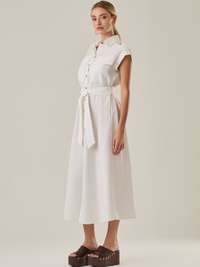 Vestido con mangas con botonadura frontal y cinturón a tono. Tiene bolsillos tipo parche en el pecho que acentúan su aire utilitario, mientras que el largo  y los botones metálicos le dan un acabado elegante y atemporal. Perfecto para un look sofisticado de día.