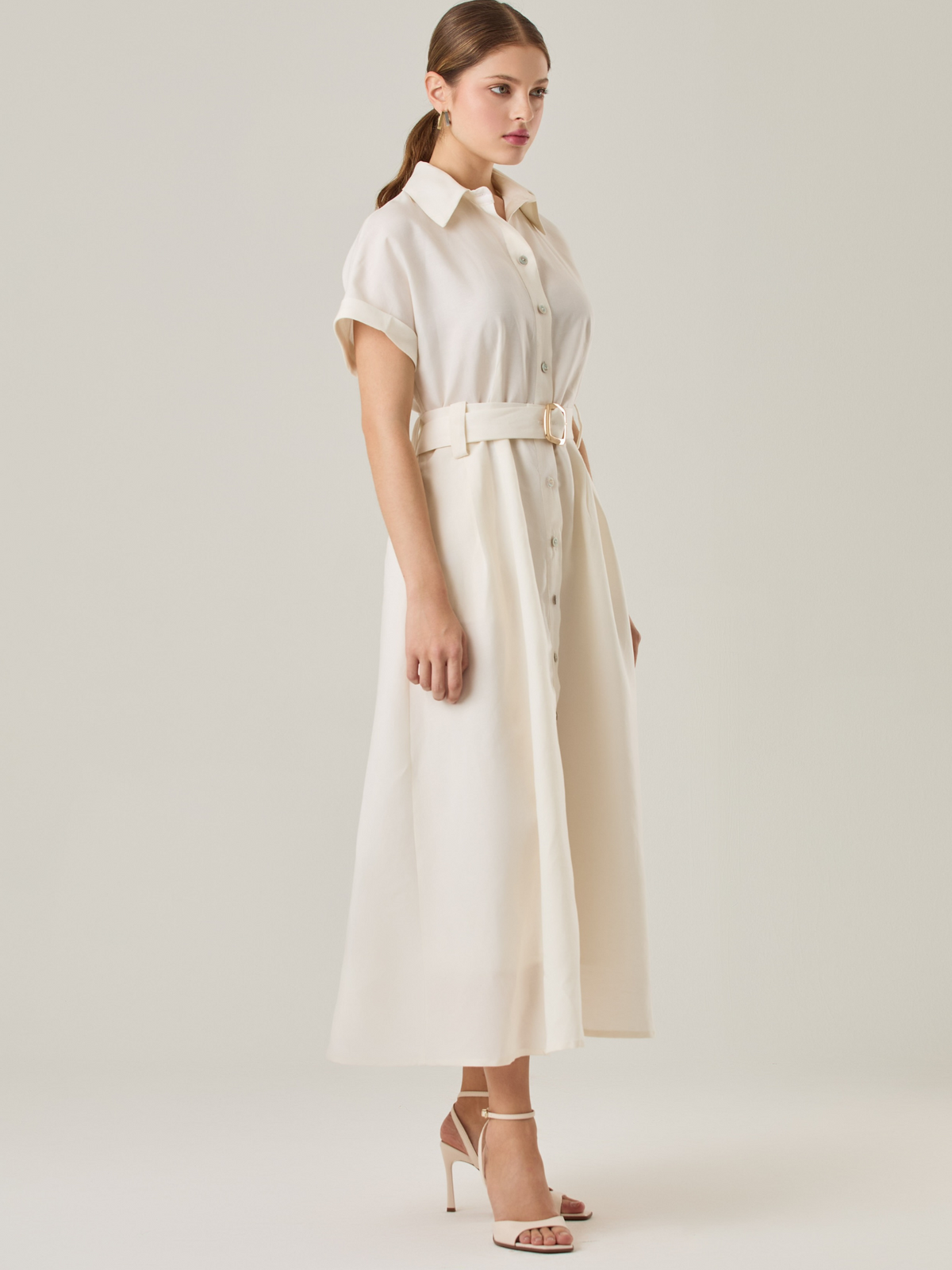 Vestido camisero de silueta midi con botonadura frontal completa y mangas cortas dobladas que aportan un aire relajado. Incorpora un cinturón del mismo material con hebilla forrada que define la cintura y realza la figura. Su estructura lo hace una prenda práctica y atemporal, perfecta para ocasiones casuales o más sofisticadas según cómo se combine.

Detalles:

Color: Blanco Perla

Material: 77% Tencel 23% Lino