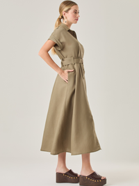 Vestido camisero de silueta midi con botonadura frontal completa y mangas cortas dobladas que aportan un aire relajado. Incorpora un cinturón del mismo material con hebilla forrada que define la cintura y realza la figura. Su estructura lo hace una prenda práctica y atemporal, perfecta para ocasiones casuales o más sofisticadas según cómo se combine.

Detalles:

Color: Olivo 