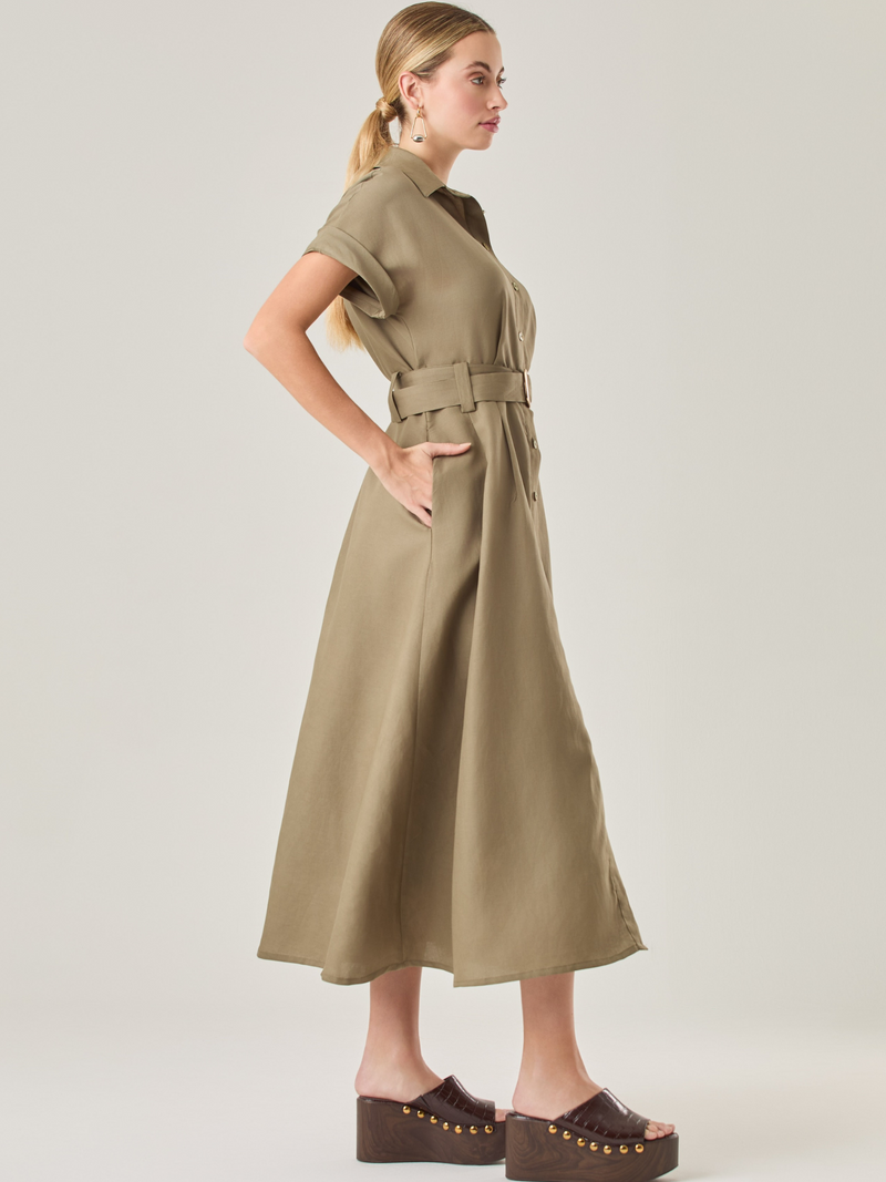 Vestido camisero de silueta midi con botonadura frontal completa y mangas cortas dobladas que aportan un aire relajado. Incorpora un cinturón del mismo material con hebilla forrada que define la cintura y realza la figura. Su estructura lo hace una prenda práctica y atemporal, perfecta para ocasiones casuales o más sofisticadas según cómo se combine.

Detalles:

Color: Olivo 