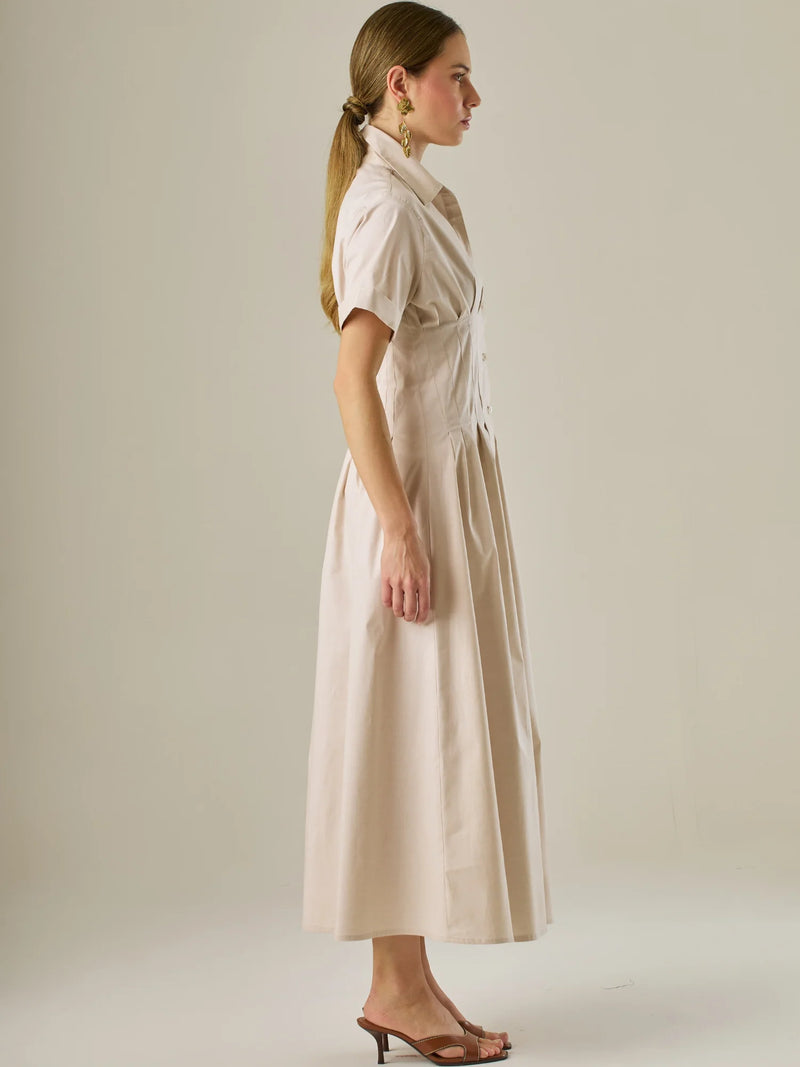Vestido camisero midi con mangas cortas y falda amplia, ideal para un look elegante y relajado. Su diseño con pinzas en el busto realza la figura con sutileza, mientras que los botones al frente aportan un toque clásico y versátil.

Detalles:

Color: Sand

Material: 97% Algodón 3% Spandex