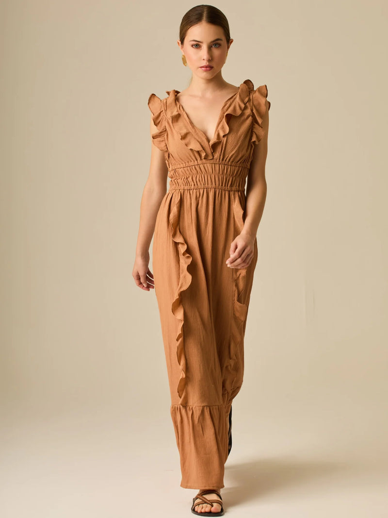 Vestido largo sin mangas con escote en "V" profundo y un diseño con volantes que recorren tanto los tirantes como la parte frontal del busto y la falda. La cintura está fruncida con elástico para dar definición y comodidad, mientras que la falda fluye suavemente con un detalle de volante en el dobladillo, aportando movimiento y un aire femenino al conjunto.

Detalles:

Color: Cafe