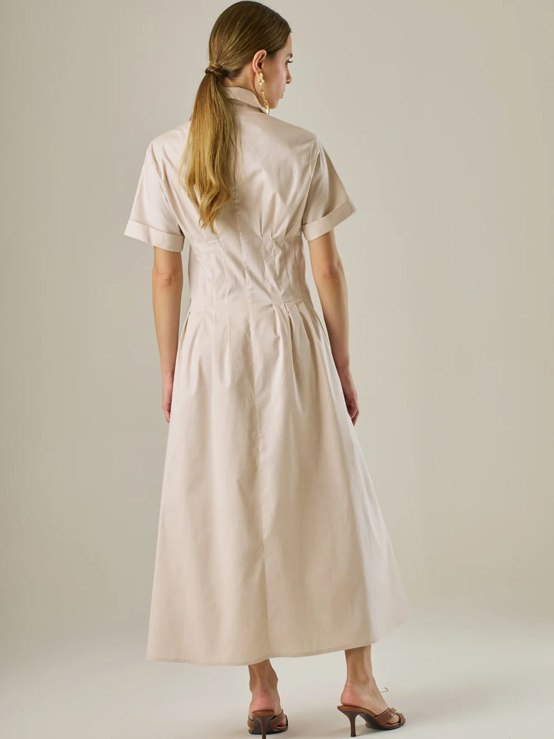 Vestido camisero midi con mangas cortas y falda amplia, ideal para un look elegante y relajado. Su diseño con pinzas en el busto realza la figura con sutileza, mientras que los botones al frente aportan un toque clásico y versátil.

Detalles:

Color: Sand

Material: 97% Algodón 3% Spandex