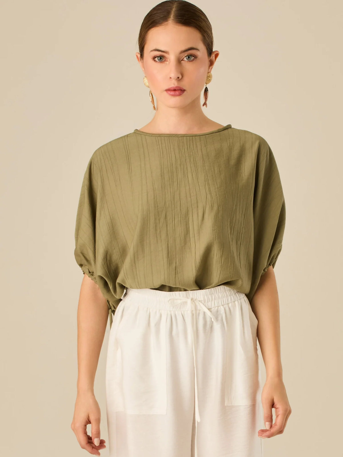 Blusa de caída ligera con detalle acanalado y mangas abullonadas ajustables. Su estilo relajado y delicado la convierte en una prenda versátil y sofisticada, perfecta para elevar looks cotidianos con elegancia sutil.

Detalles:

Color: Olivo