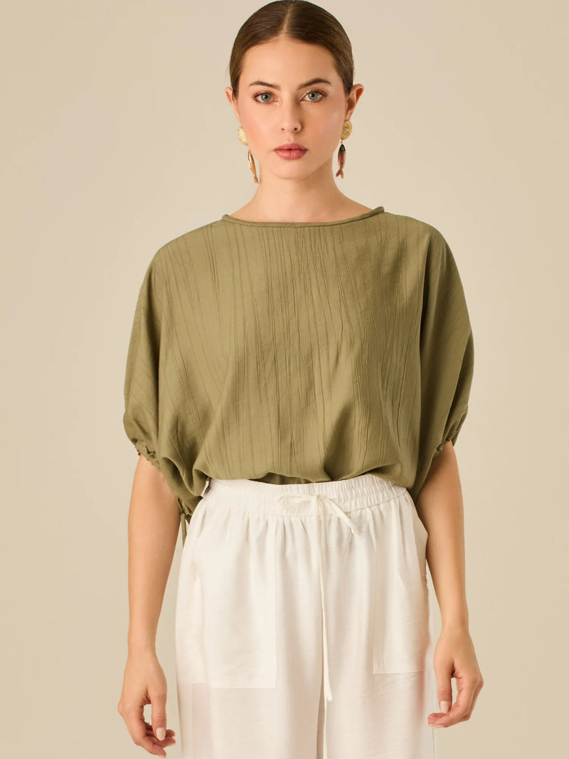 Blusa de caída ligera con detalle acanalado y mangas abullonadas ajustables. Su estilo relajado y delicado la convierte en una prenda versátil y sofisticada, perfecta para elevar looks cotidianos con elegancia sutil.

Detalles:

Color: Olivo
