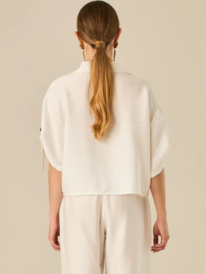 Blusa de silueta relajada con botones al frente, bolsillos tipo parche y mangas con detalle de amarre que aporta un aire desenfadado y chic. Su estilo versátil la convierte en una opción perfecta para looks casuales con un toque sofisticado.

Detalles:

Color: Blanco
