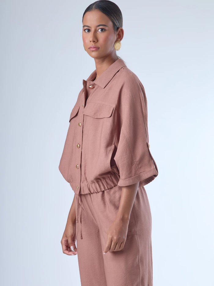 Relajada pero estructurada, esta blusa de silueta amplia combina un diseño utilitario con detalles refinados. Presenta bolsillos de solapa en el pecho, mangas con opción de ajuste y una botonadura dorada que aporta un toque de brillo sutil. Ideal para estilismos casuales con elegancia natural, o para elevar conjuntos relajados con una prenda clave y atemporal.
