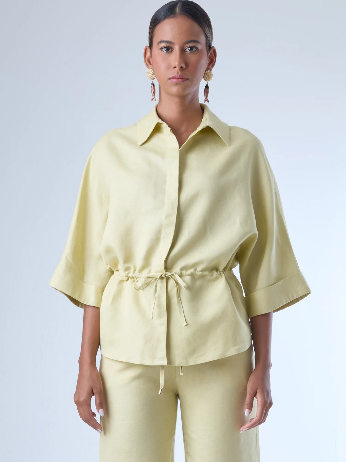 Blusa sin mangas de corte recto y silueta relajada. Tiene cuello redondo cerrado y un diseño limpio sin detalles visibles, lo que le da un estilo minimalista y moderno. El largo llega justo a la cintura, ideal para llevar por fuera o combinada con prendas de talle alto para un look fresco y sofisticado